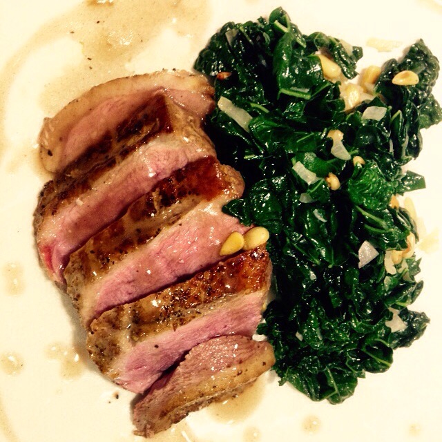 Ankbröst med svartkål, pinjenötter och schalottenlök.